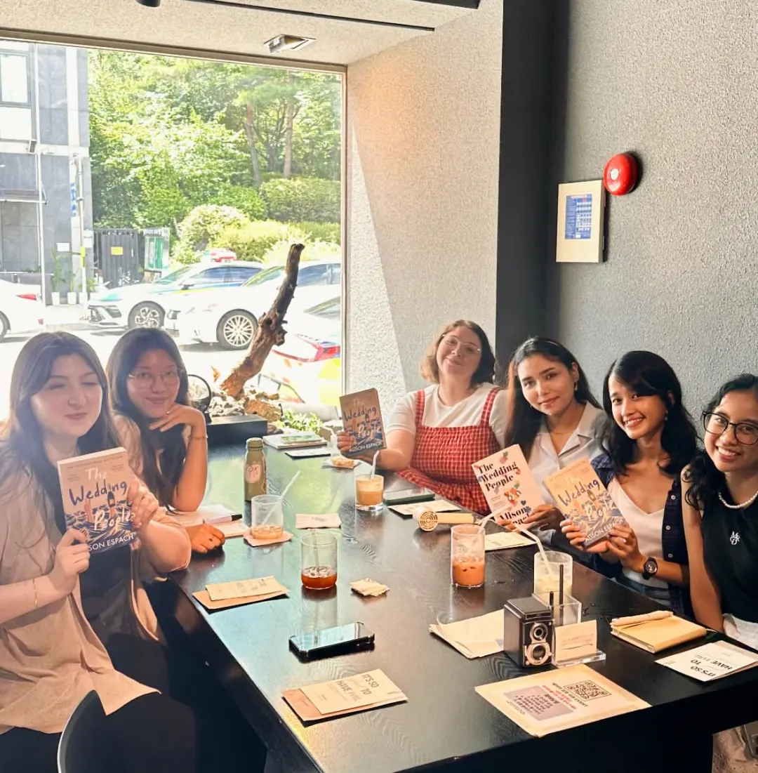 Book club members in Seoul holding copies of The Wedding People