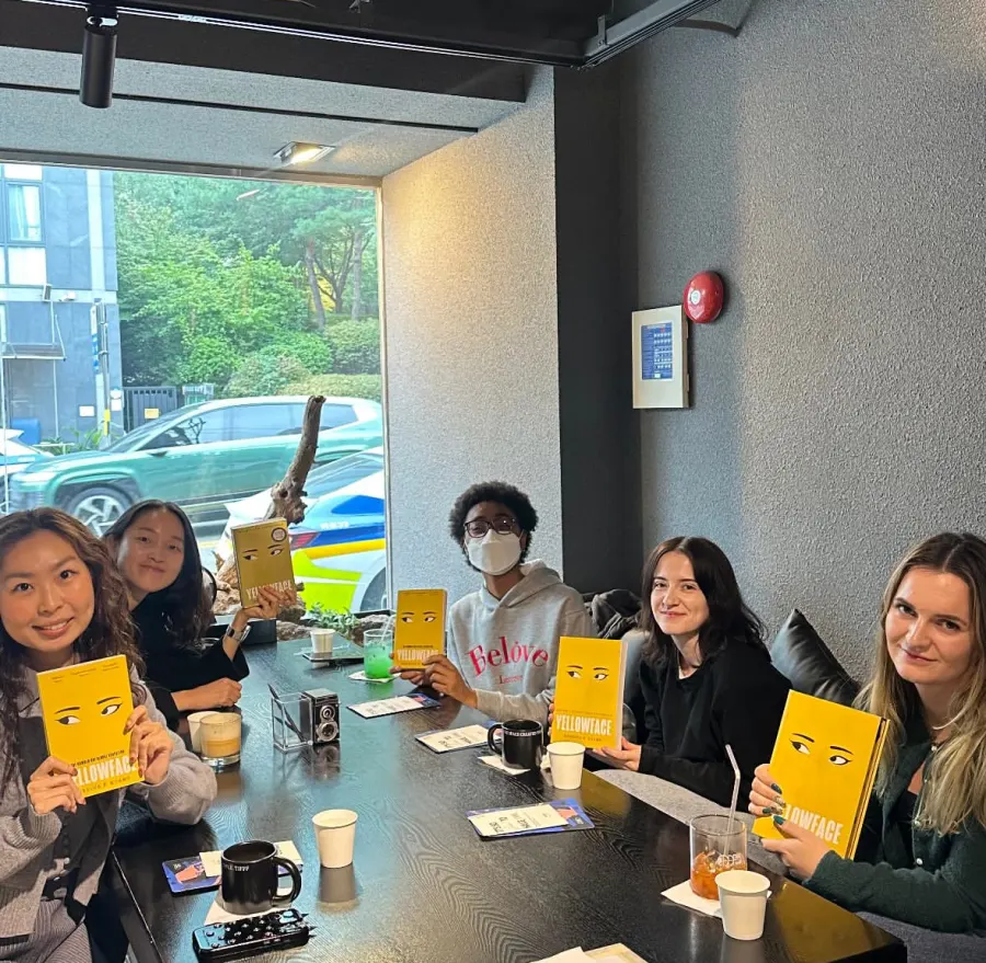 Members discuss Yellowface by R. F. Kuang at a cafe in Seoul